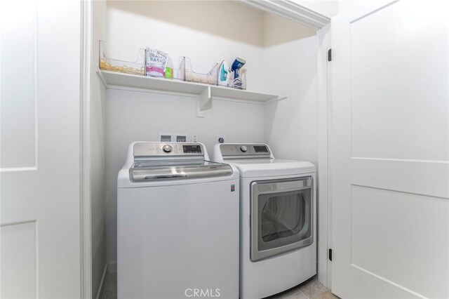 washroom with light tile patterned flooring and washing machine and clothes dryer