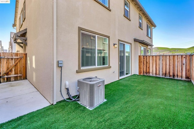 rear view of house featuring a yard and central AC