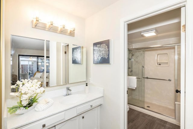 bathroom featuring hardwood / wood-style flooring, vanity, and a shower with door