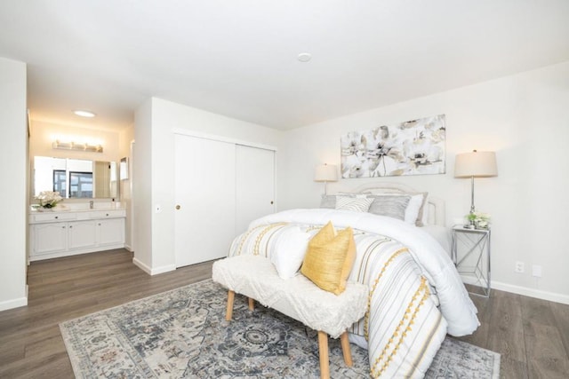 bedroom with dark hardwood / wood-style flooring, ensuite bath, and a closet