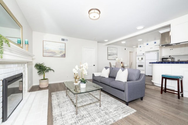 living room with light hardwood / wood-style flooring and a fireplace