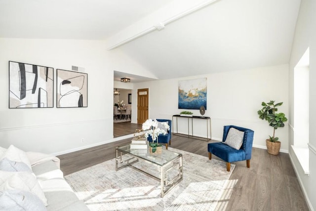 living room featuring vaulted ceiling with beams and hardwood / wood-style floors