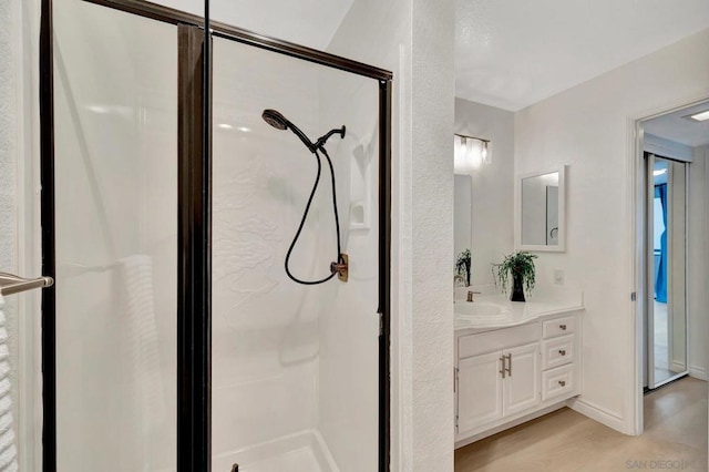 bathroom featuring hardwood / wood-style floors, an enclosed shower, and vanity