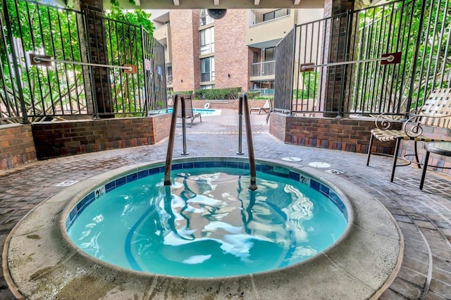 view of pool with a community hot tub and a patio