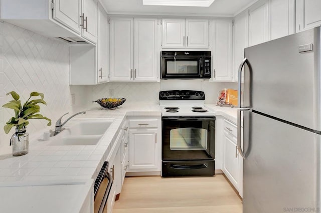 kitchen with white cabinetry, sink, tile countertops, and black appliances