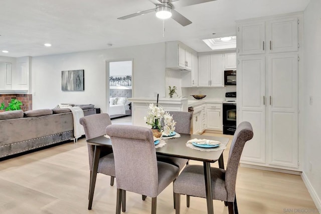 dining room with ceiling fan and light wood-type flooring