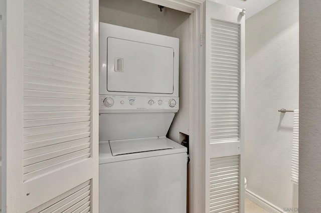 washroom featuring stacked washer / drying machine