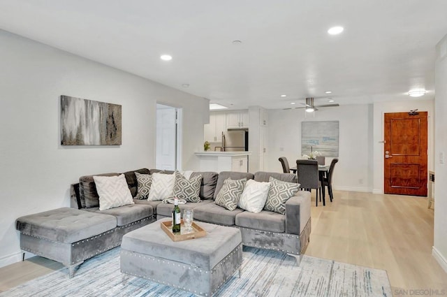 living room featuring ceiling fan and light wood-type flooring