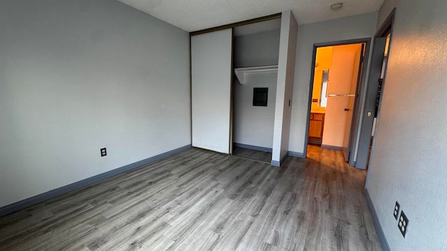 unfurnished bedroom featuring wood-type flooring and a closet