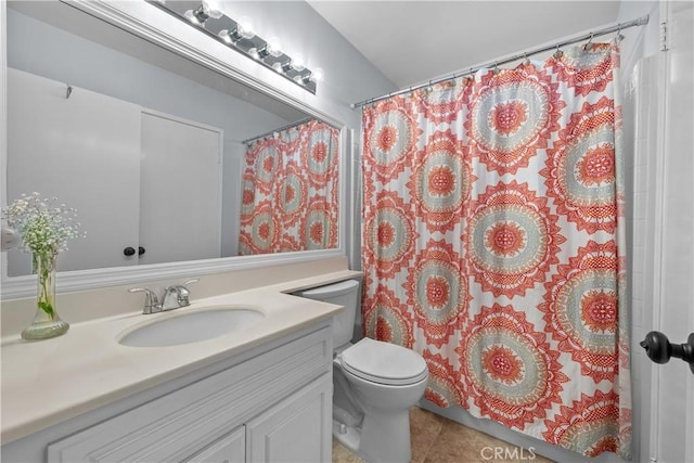 bathroom with toilet, tile patterned floors, vanity, and curtained shower