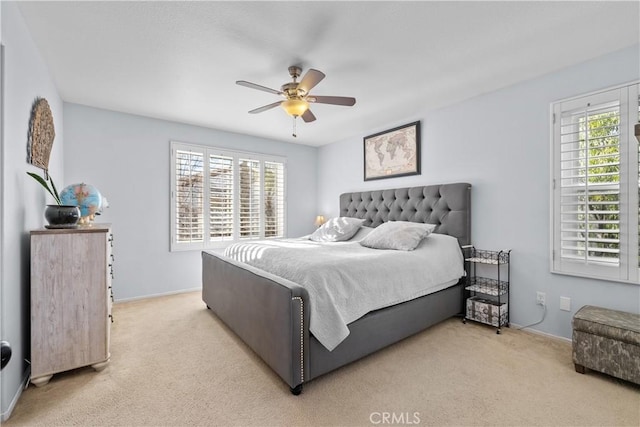 carpeted bedroom featuring ceiling fan and multiple windows