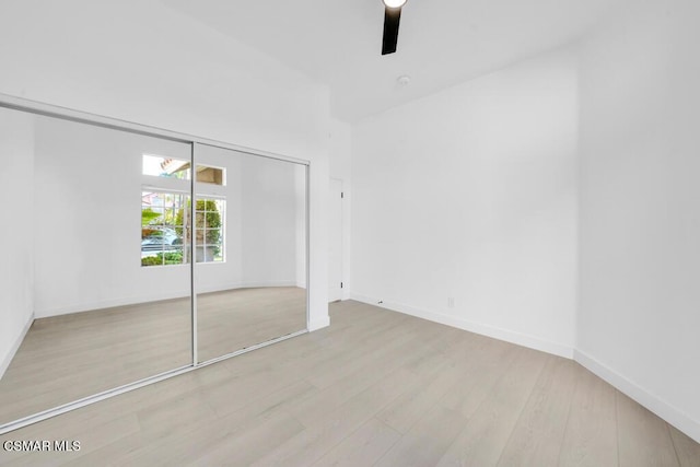 unfurnished bedroom with ceiling fan, a closet, and light hardwood / wood-style flooring