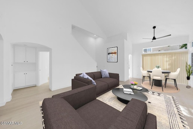 living room featuring ceiling fan, light hardwood / wood-style flooring, and high vaulted ceiling