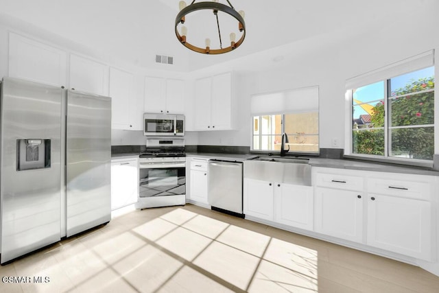 kitchen featuring a wealth of natural light, stainless steel appliances, and white cabinetry