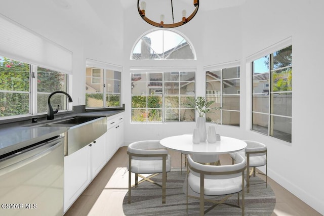 sunroom featuring sink and a notable chandelier