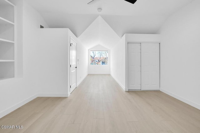 bonus room with light hardwood / wood-style flooring, built in features, and vaulted ceiling