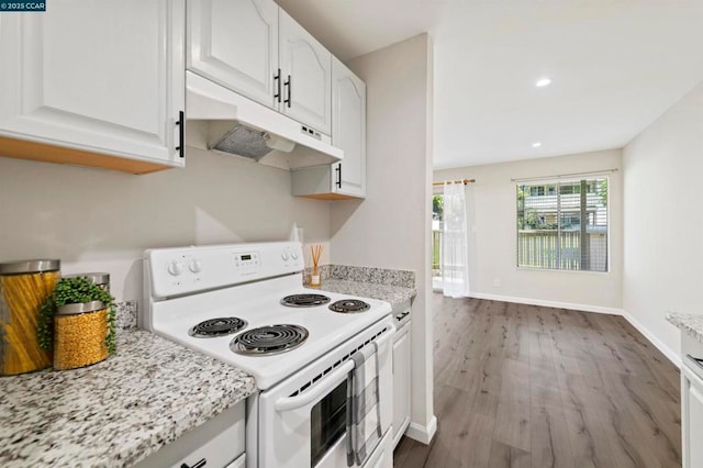 kitchen with hardwood / wood-style floors, white electric range, white cabinetry, and light stone countertops