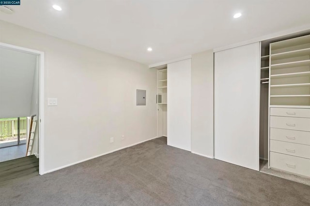 unfurnished bedroom featuring electric panel and dark colored carpet