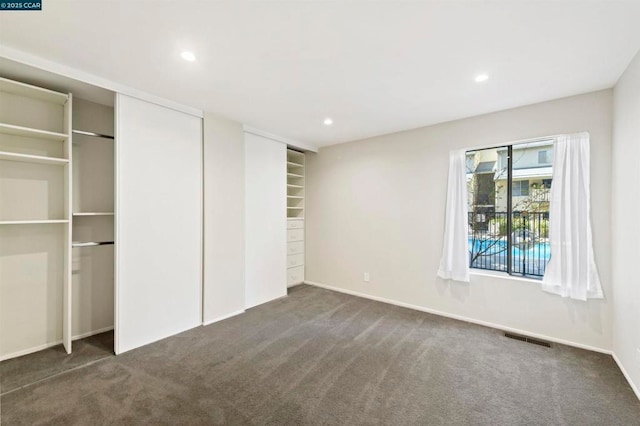 unfurnished bedroom featuring dark carpet