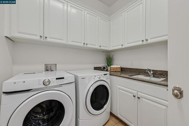 laundry area featuring cabinets, sink, light tile patterned floors, and separate washer and dryer