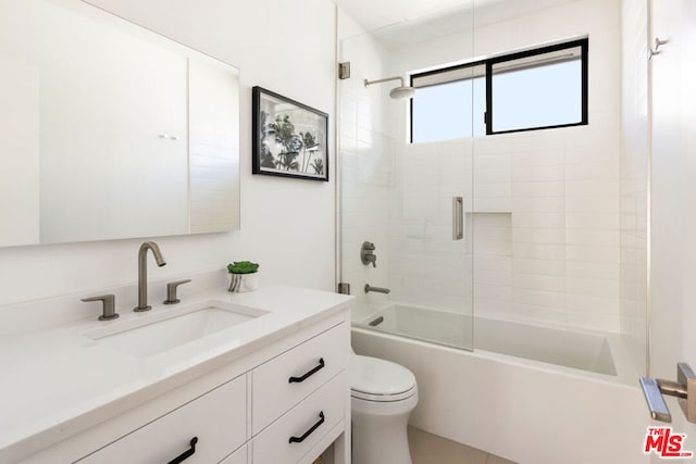 full bathroom with bath / shower combo with glass door, toilet, and vanity