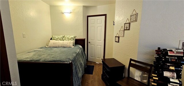 bedroom with dark hardwood / wood-style flooring