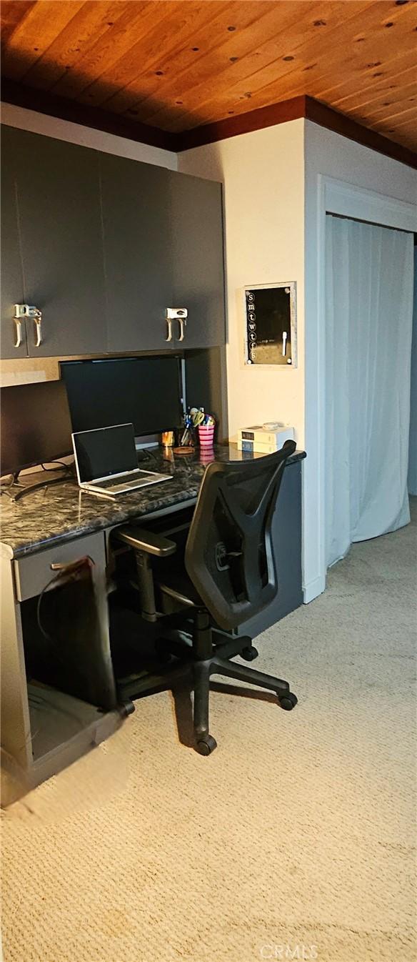 carpeted home office with wooden ceiling