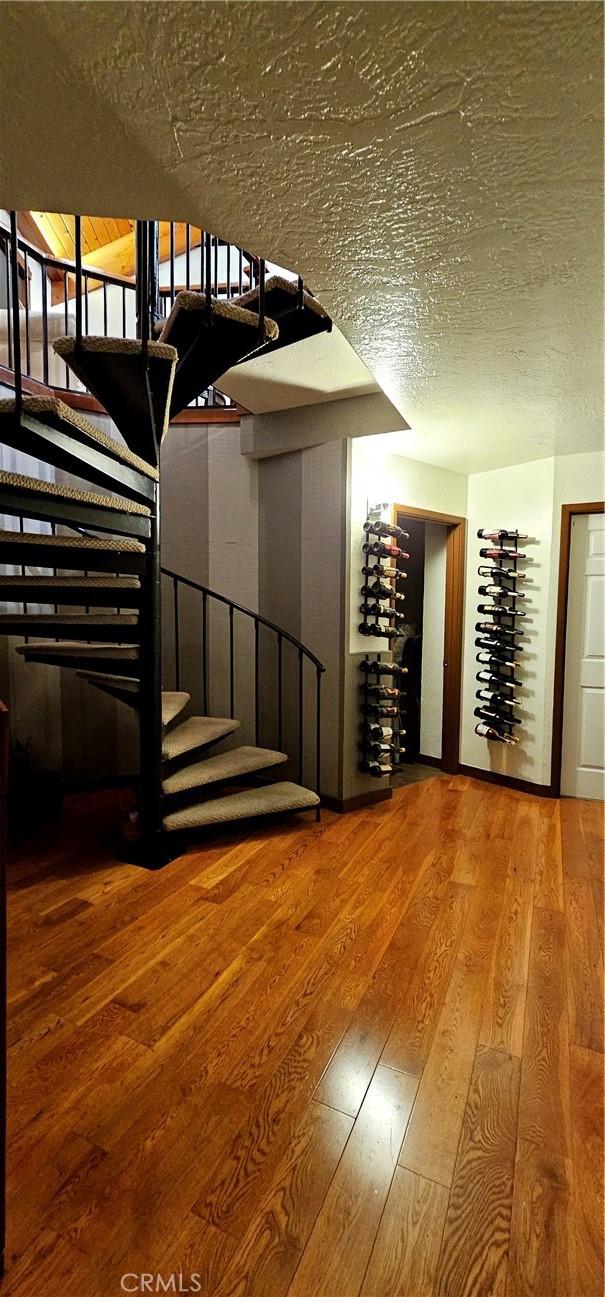 wine cellar with hardwood / wood-style flooring and a textured ceiling