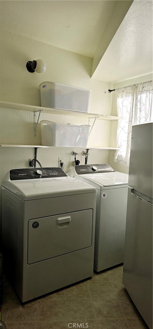 clothes washing area with washer and clothes dryer