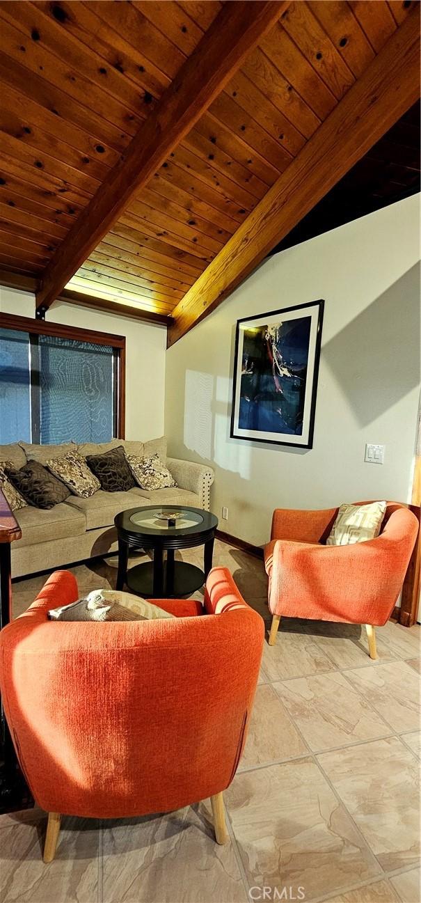 living room featuring vaulted ceiling with beams and wooden ceiling