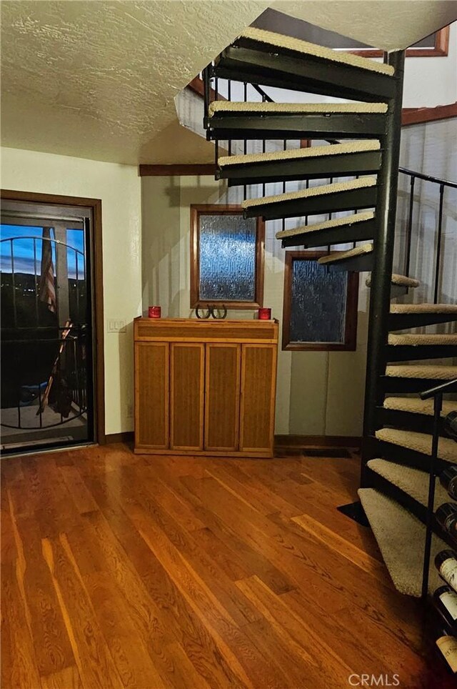 interior space featuring wood-type flooring and a textured ceiling