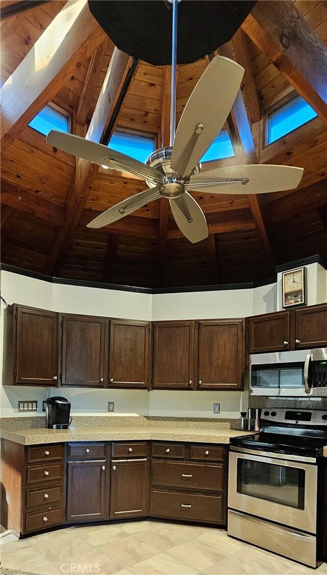 kitchen featuring stainless steel appliances, ceiling fan, wood ceiling, and high vaulted ceiling