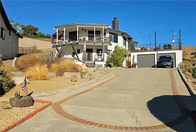 view of front of home with a balcony, a garage, an outdoor structure, and covered porch