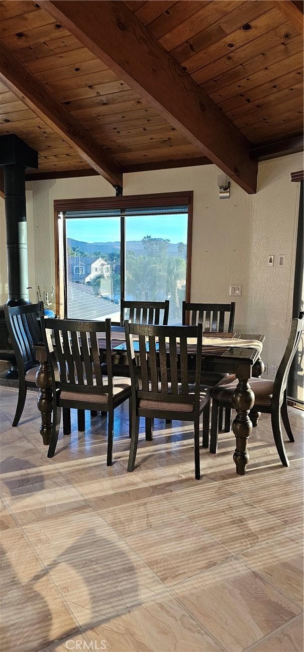 dining area featuring beam ceiling, a mountain view, and wood ceiling