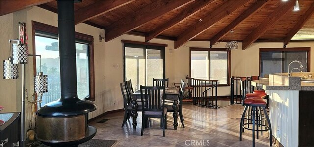 dining area with a notable chandelier, wooden ceiling, and a wealth of natural light