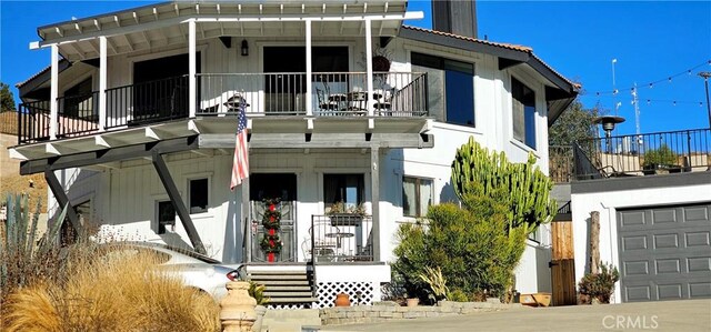 view of front of property with a balcony, covered porch, and a garage