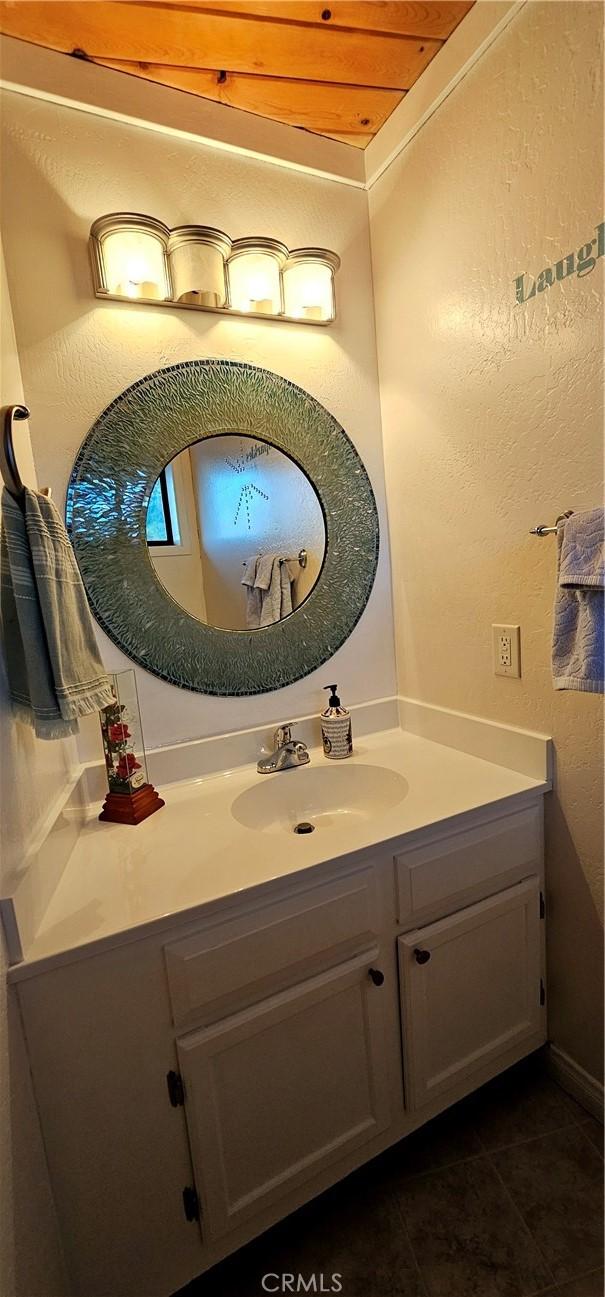 bathroom featuring vanity, tile patterned flooring, and wooden ceiling