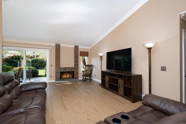 living room with ornamental molding, lofted ceiling, a fireplace, and light wood-type flooring