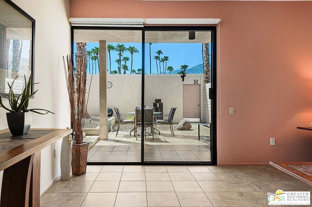 doorway to outside featuring a wealth of natural light and light tile patterned flooring