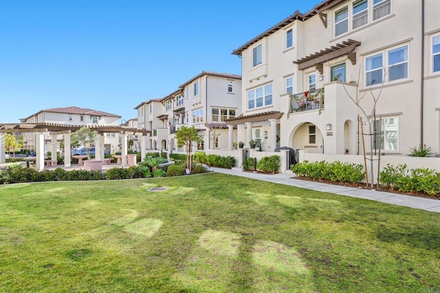 view of home's community with a pergola and a lawn