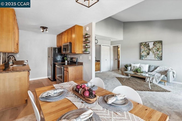 carpeted dining room with lofted ceiling and sink