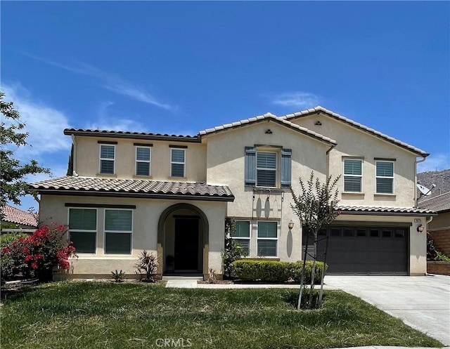 mediterranean / spanish-style house featuring a front yard and a garage