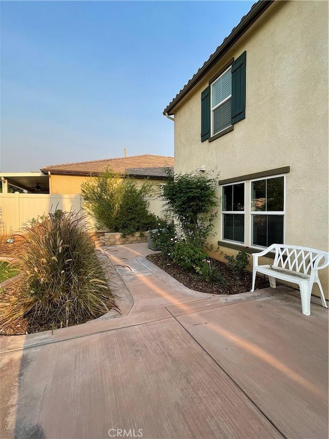 view of home's exterior featuring a patio, fence, and stucco siding