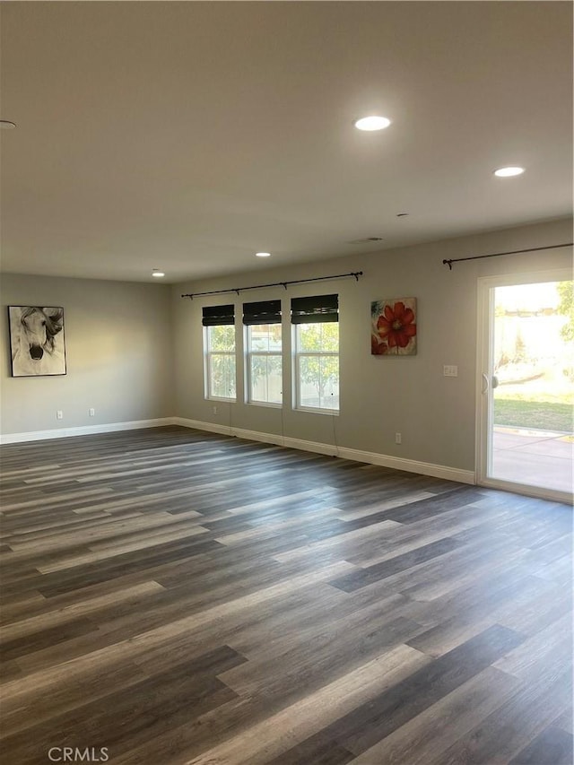 spare room featuring dark wood-type flooring, recessed lighting, and baseboards