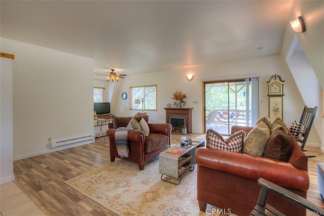 living room featuring a baseboard heating unit, ceiling fan, and light hardwood / wood-style flooring