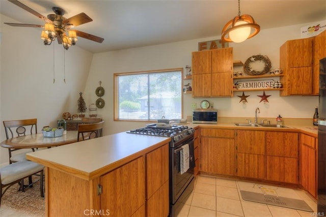 kitchen with decorative light fixtures, ceiling fan, gas stove, sink, and light tile patterned floors