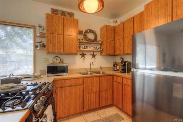 kitchen featuring light tile patterned floors, sink, a wealth of natural light, and appliances with stainless steel finishes