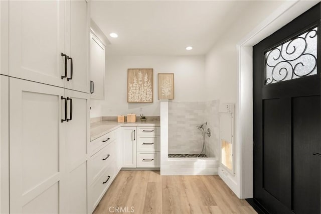 bathroom featuring vanity, tiled shower, and hardwood / wood-style floors