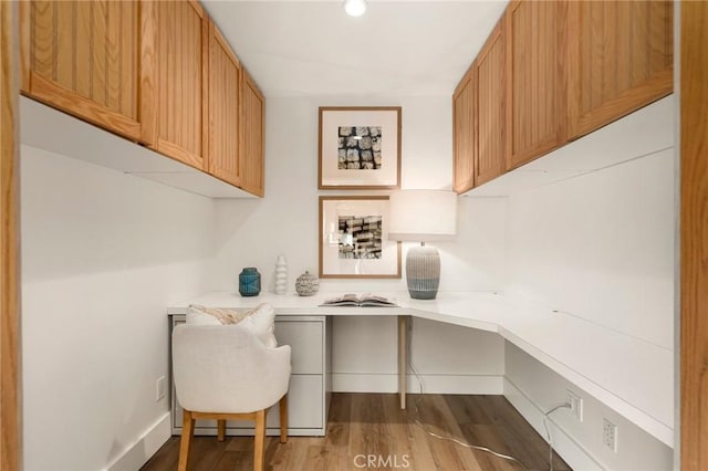 office space featuring built in desk and dark hardwood / wood-style floors