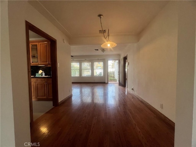 unfurnished dining area featuring dark wood-style floors and baseboards